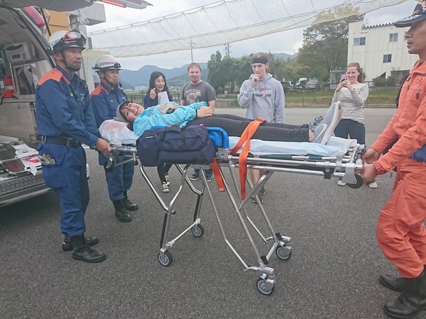 ワラワラ市から来られた方々が消防隊員とタンカーや救急車を、見学している様子