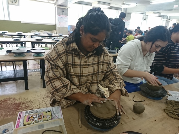ワラワラ市から来られた方が椅子に座って丹波焼の土をこねている写真