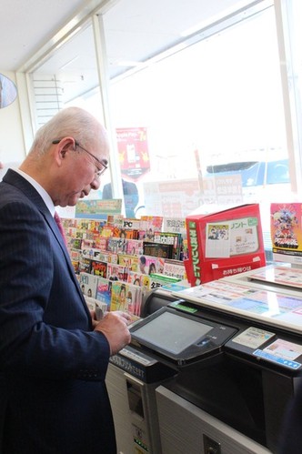 市長がコピー機を操作している様子を写した写真。