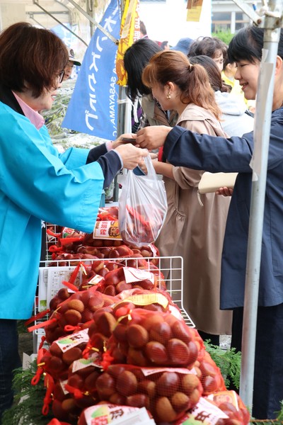 丹波栗を購入する女性客と手渡す青いはっぴを着た女性