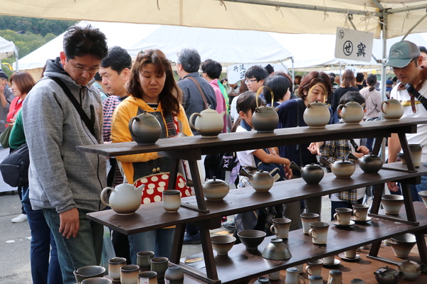 丹波焼の商品を見つめる夫婦や親子、多くの人でにぎわっている会場の様子