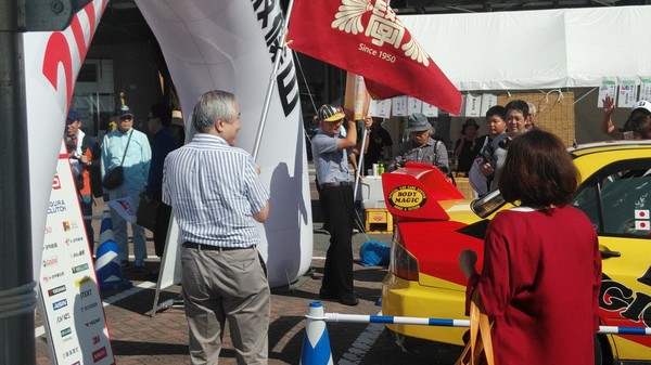 男性が二名、旗を振っている写真