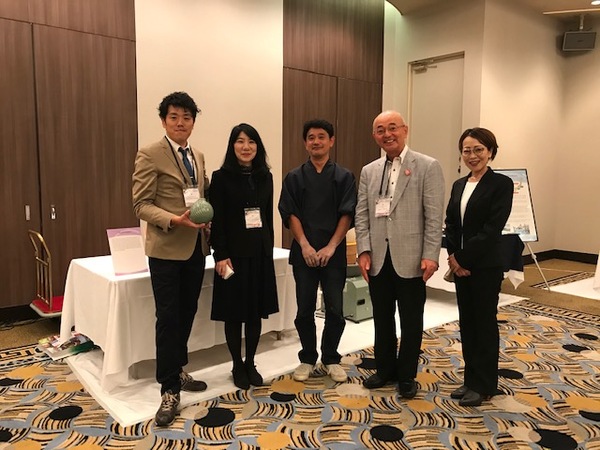 会議場にて王地山焼の作家の竹内さん、一番右が仙林さんと市長、市職員が笑顔で立って並んでいる写真