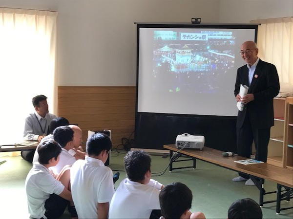 スクリーンにデカンショ祭を投影し市長が生徒たちに説明している様子