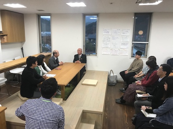 机に市長を囲むように座って対談しながらその様子を椅子に座り聞いている方々の写真