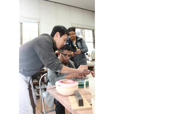 チェンマイの方々が丹波焼を教わりながらいっしょに土をこねている様子の写真
