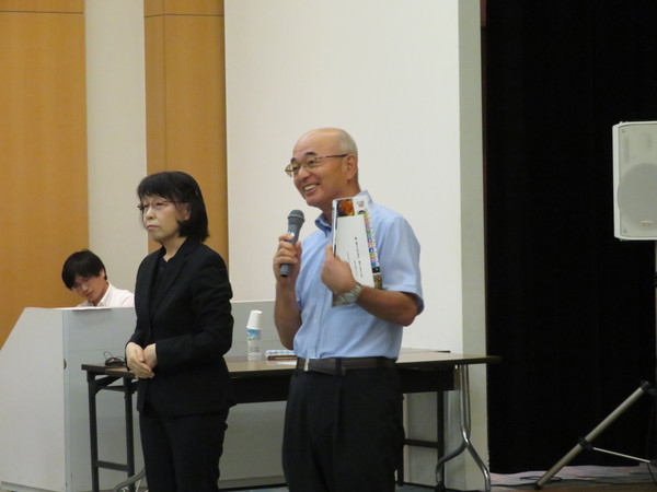 マイクを持ち笑顔で話す市長と手話通訳の方が立っている写真