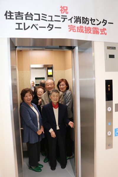 完成エレベーター内に乗りこむ五名の男性女性