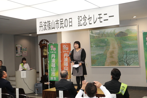 丹波篠山市民の日記念セレモニーと書かれたプレートの下で挨拶をする畑弘恵さんの写真