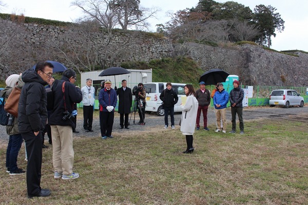 防寒着を着て広場で説明を受ける男性女性