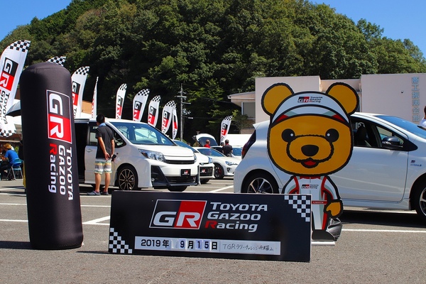 数台の展示車と熊のパネルが並んでいる写真