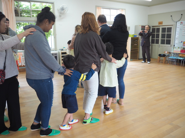 ワラワラ市から来られた方々が子どもたちと肩を持ちながら列を作り楽しんでいる様子