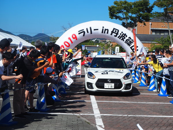 白いスポーツカーがゲートから出発する写真