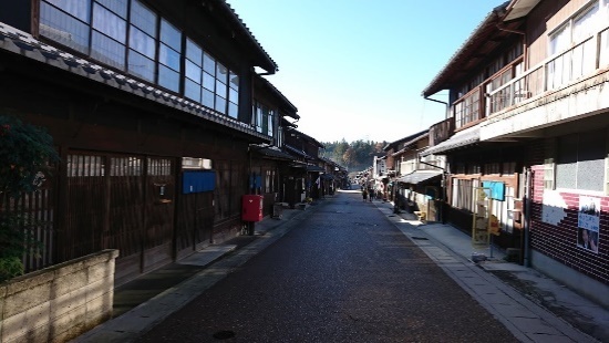 まっすぐな通りのそばに伝統的な建築物が立ち並んでいる様子の写真