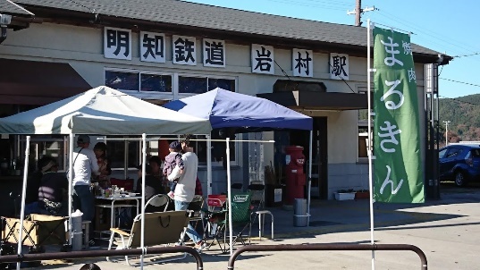 明智鉄道岩村駅の駅舎とその前にテントを広げて人々が集まっている様子の写真