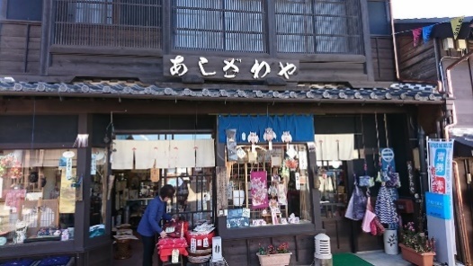 伝統的な建物の軒先でのれんをだし、商品やガラス戸内に展示された商品の写真