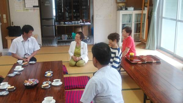 畳の部屋で職員と女性数名が座って話をしている写真