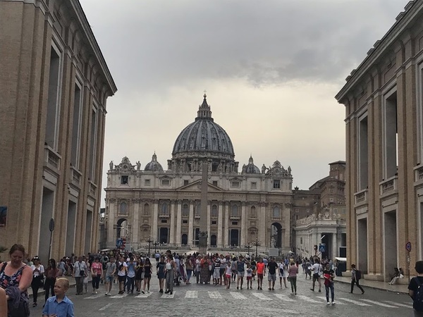 壮大なヨーロッパの建築物の前に多くの人々が観光、歩いている様子