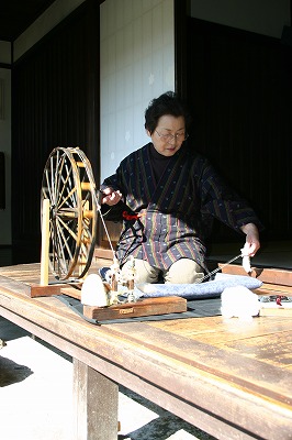 糸紡ぎをする女性の写真