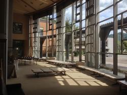 丸みを帯びた大きなガラス越しに日が差し込む四季の森生涯学習センターのホワイエ(ロビー)の写真