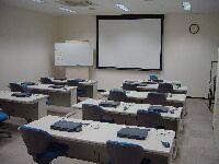 各机にノートパソコンが置かれているIT講習室の室内写真