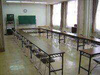 3人掛けの机と椅子が並べられた1階展示室の室内写真