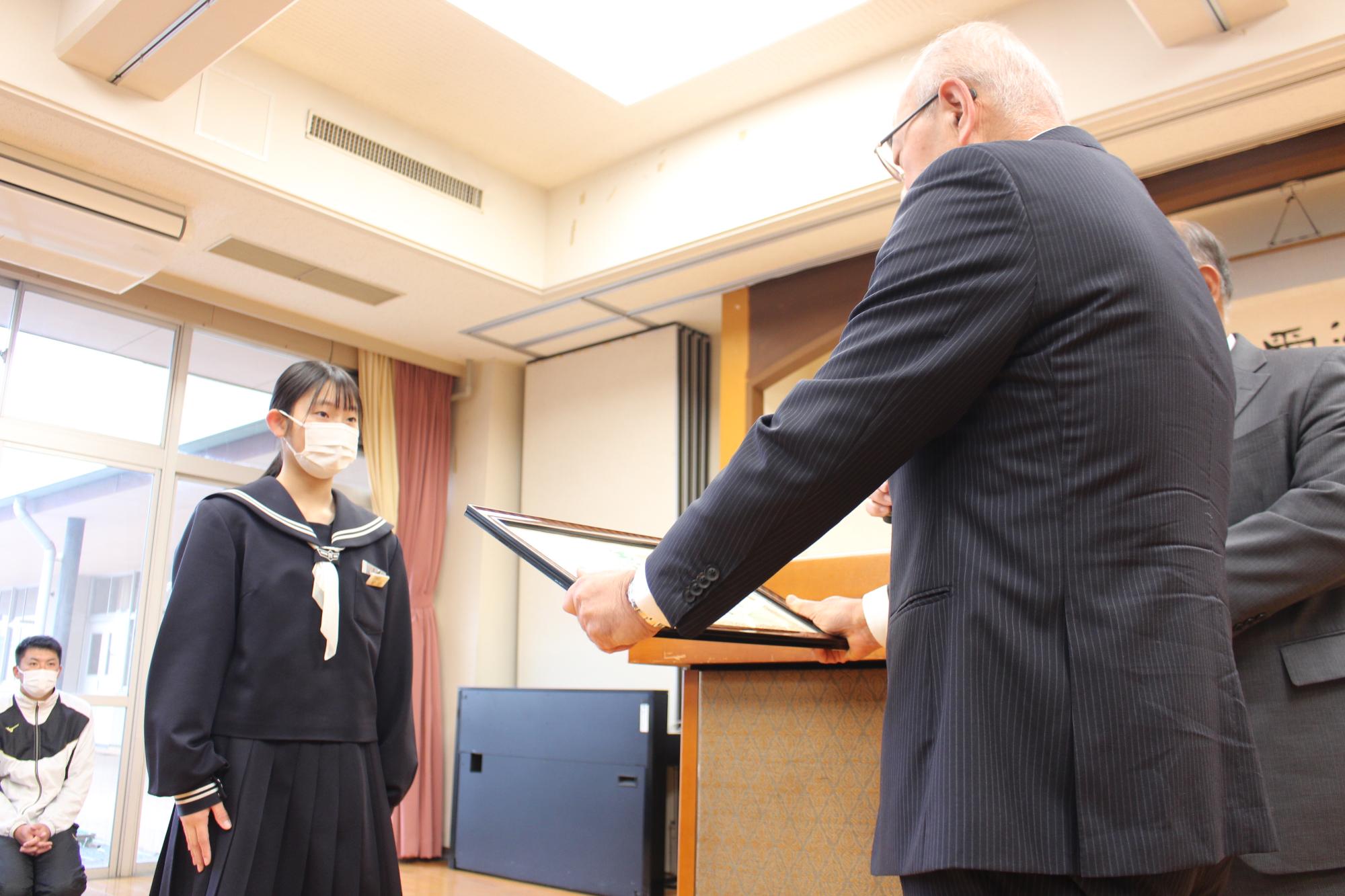 賞状を渡す市長と受け取る安田さん