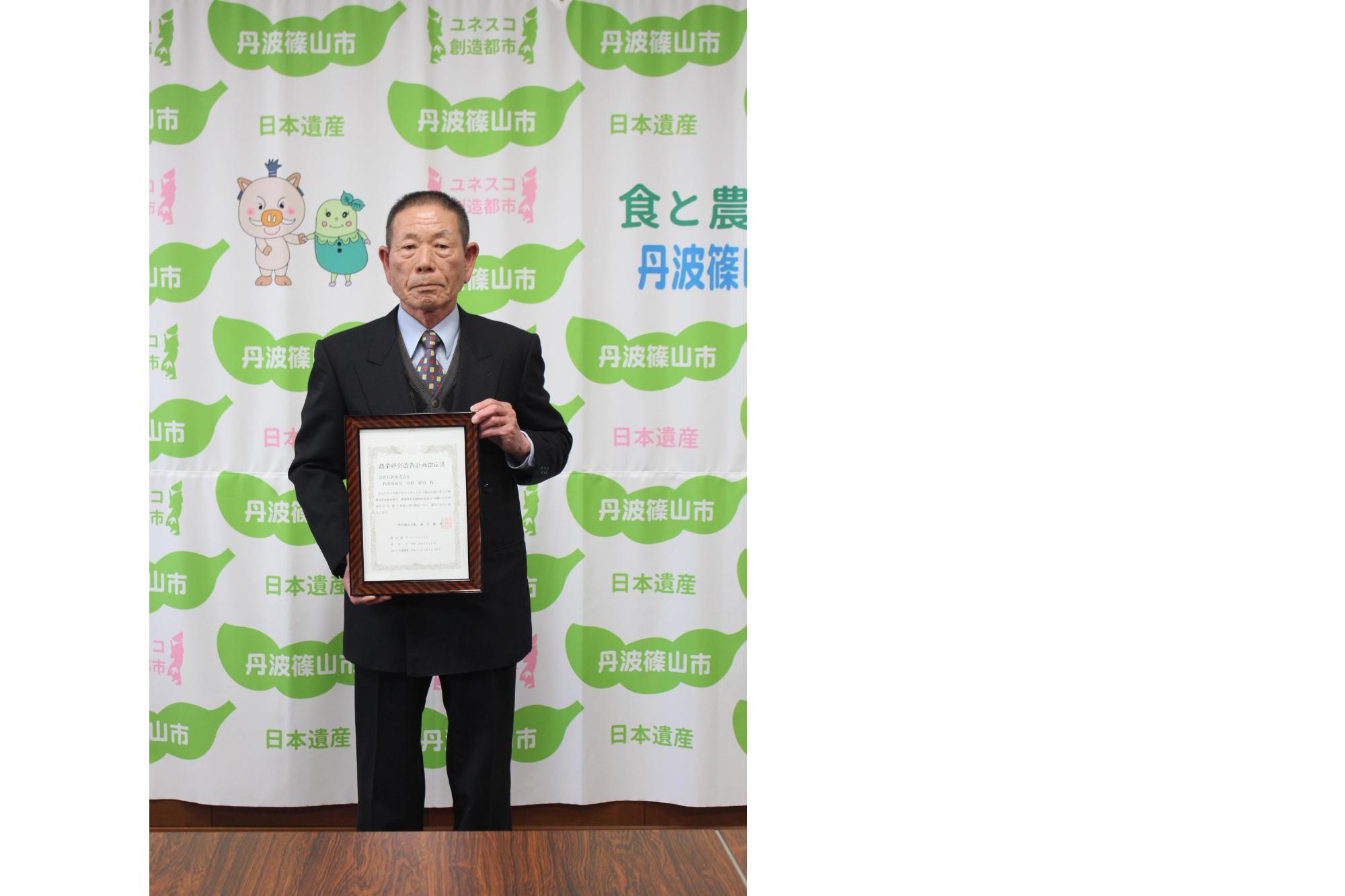 認定書を持って撮影した谷垣さん