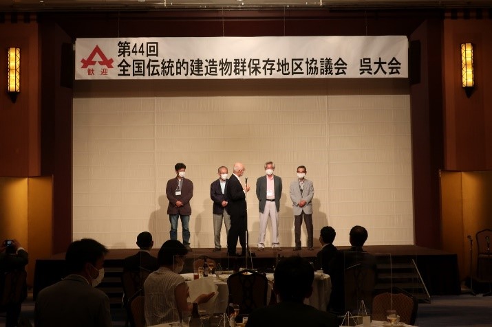 舞台上で、男性5人が前に出てしゃべっている