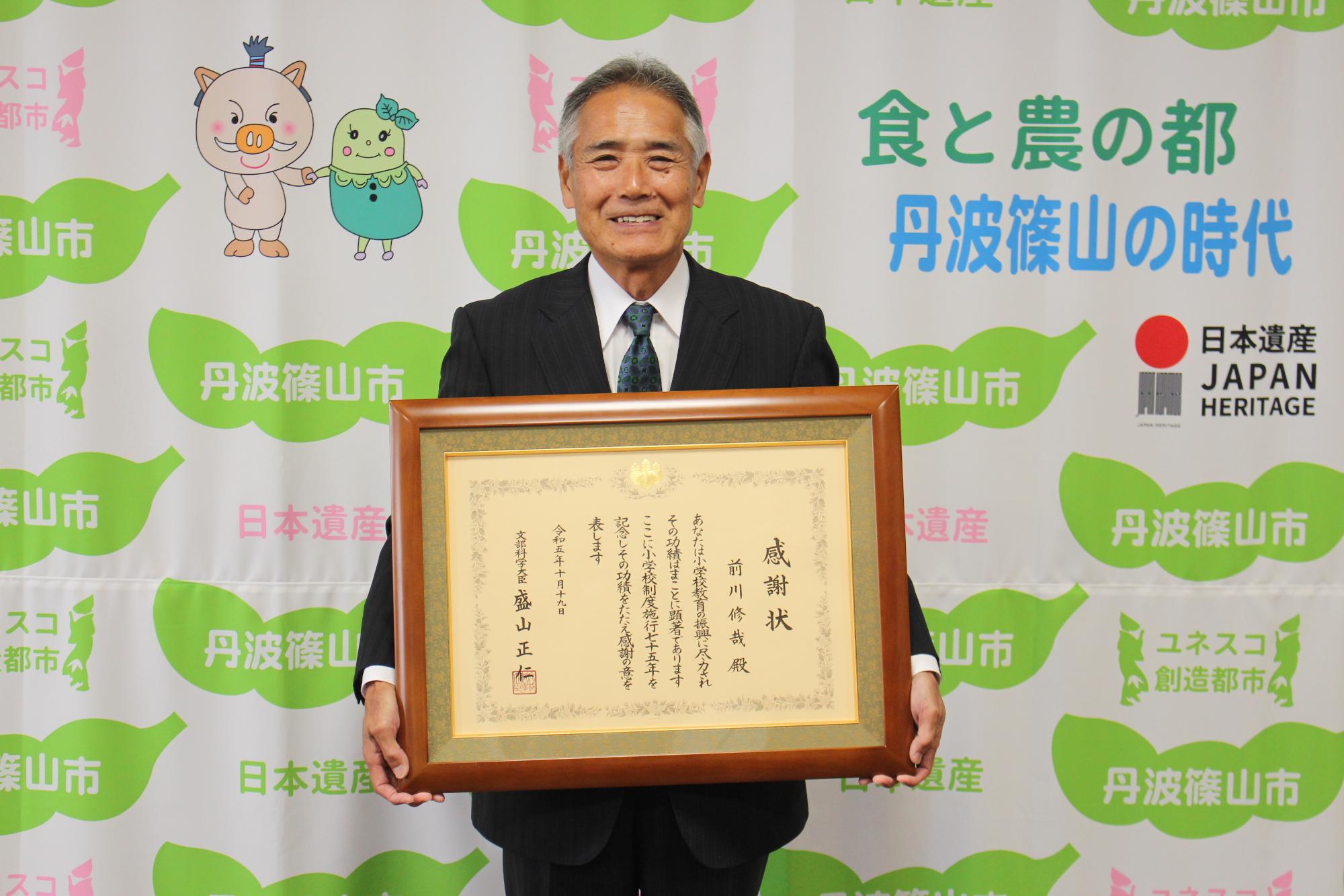感謝状を持って写る前川修哉さん