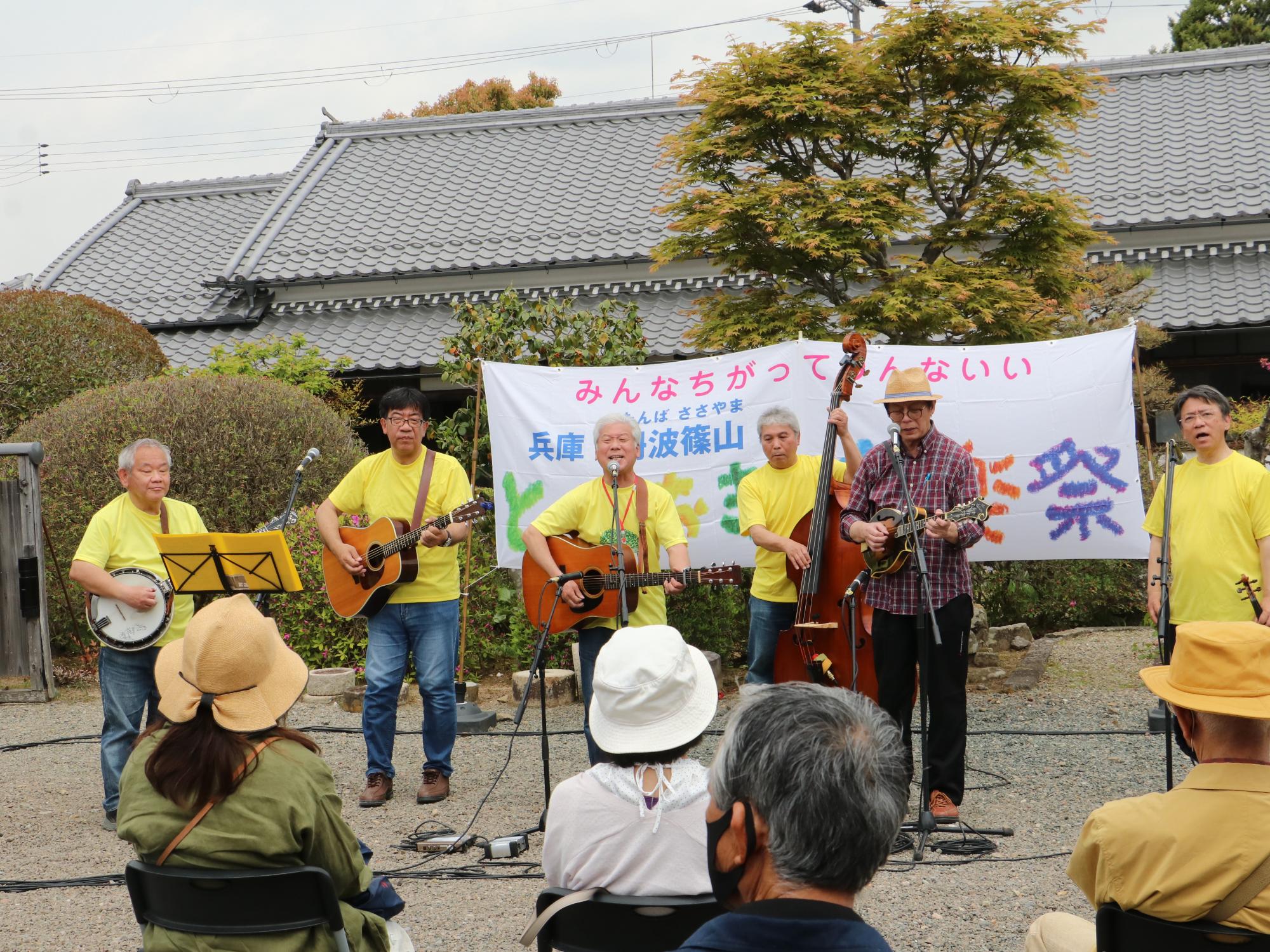 ギターやウクレレを弾きながら男の人達がうたっている