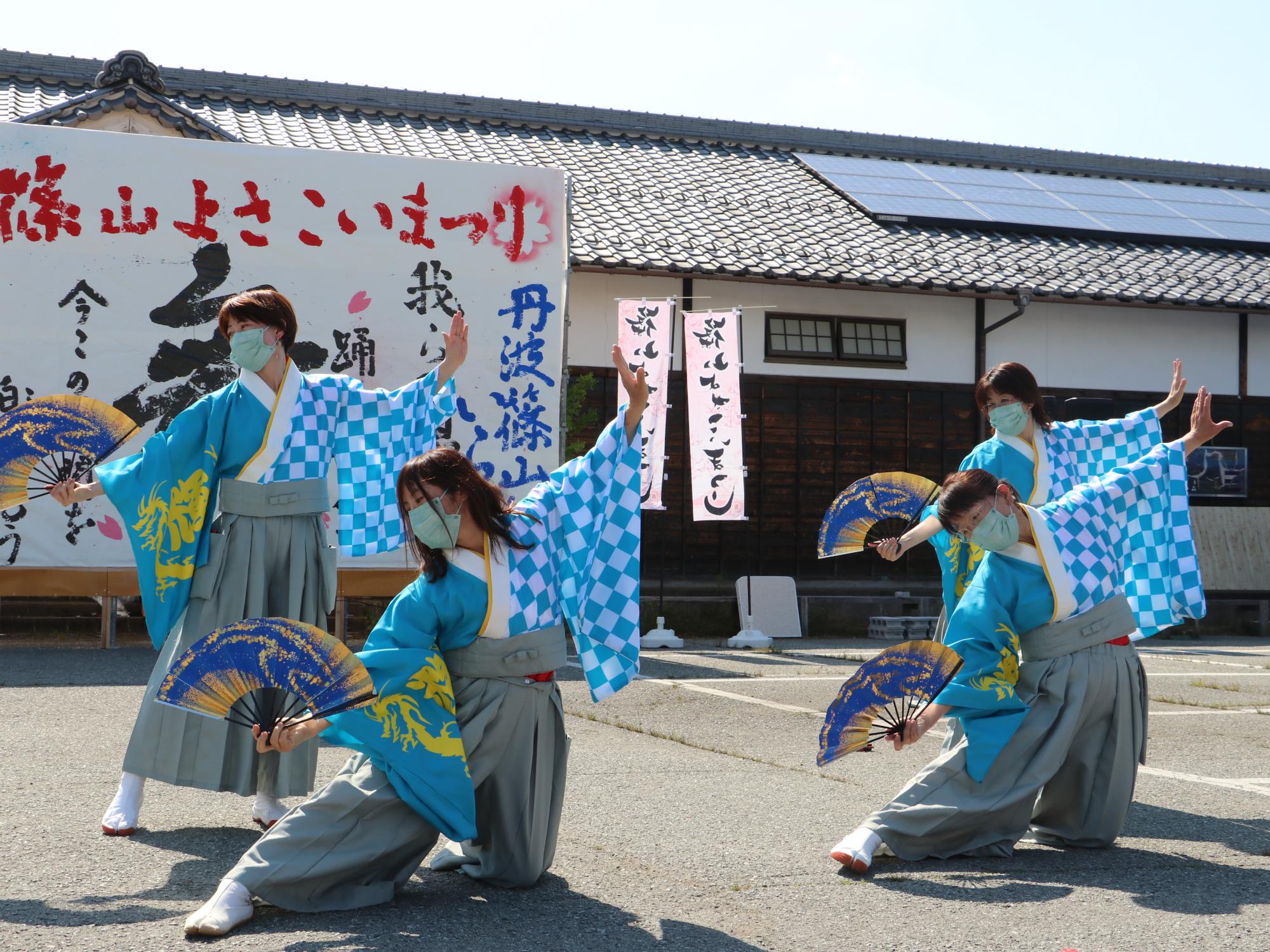 水色の袴を着て扇子を持って踊っている