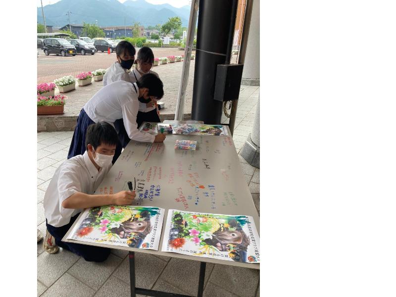 模造紙に、学生たちが色とりどりのサインペンでメッセージを書いている