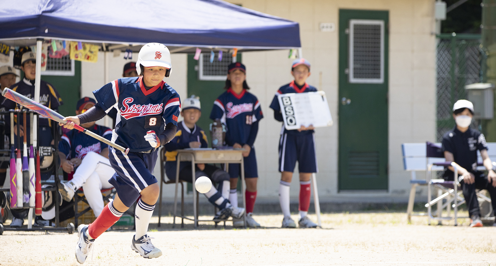ソフトボールの試合で、バントして走ろうとしている