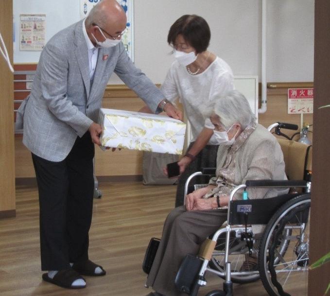 市長がご長寿の方にお祝いの品を渡している