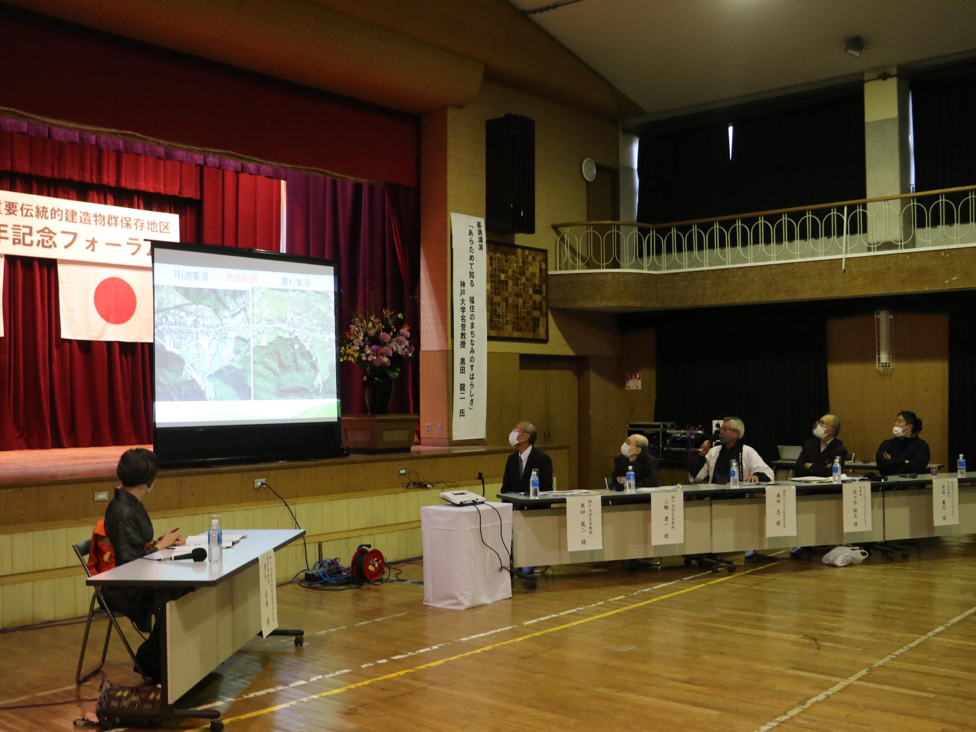 体育館でスライドを使って講演されている