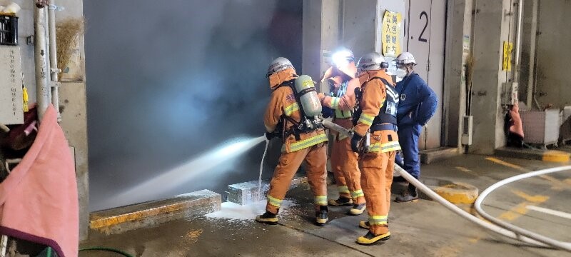 消防隊員が、清掃センターで消火作業を行っている