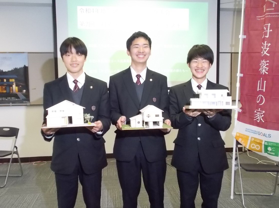 建築コンテストで受賞した3人の生徒が家の模型と記念撮影