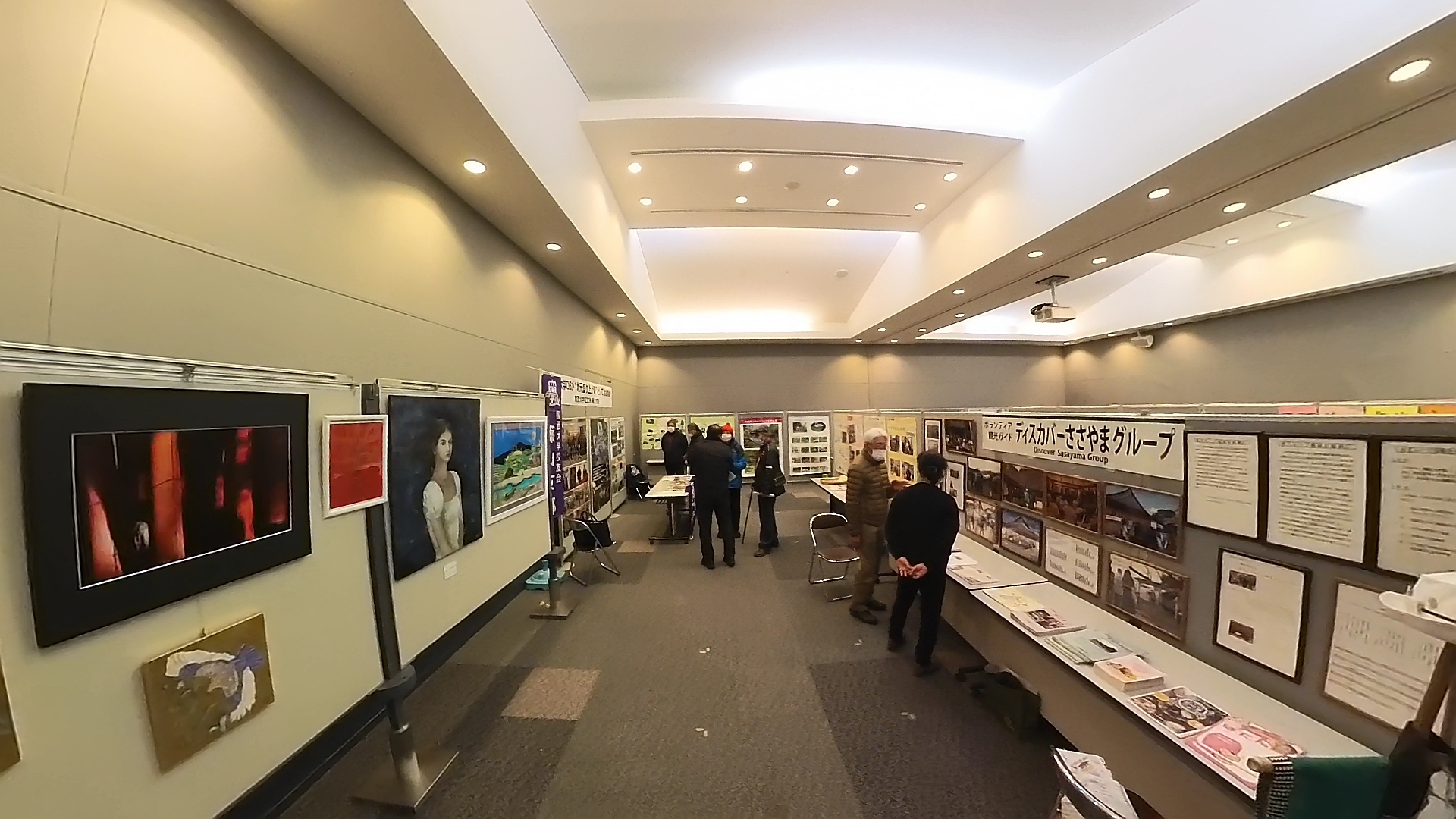 イベントの展示ブースで絵画や研究成果が展示されている