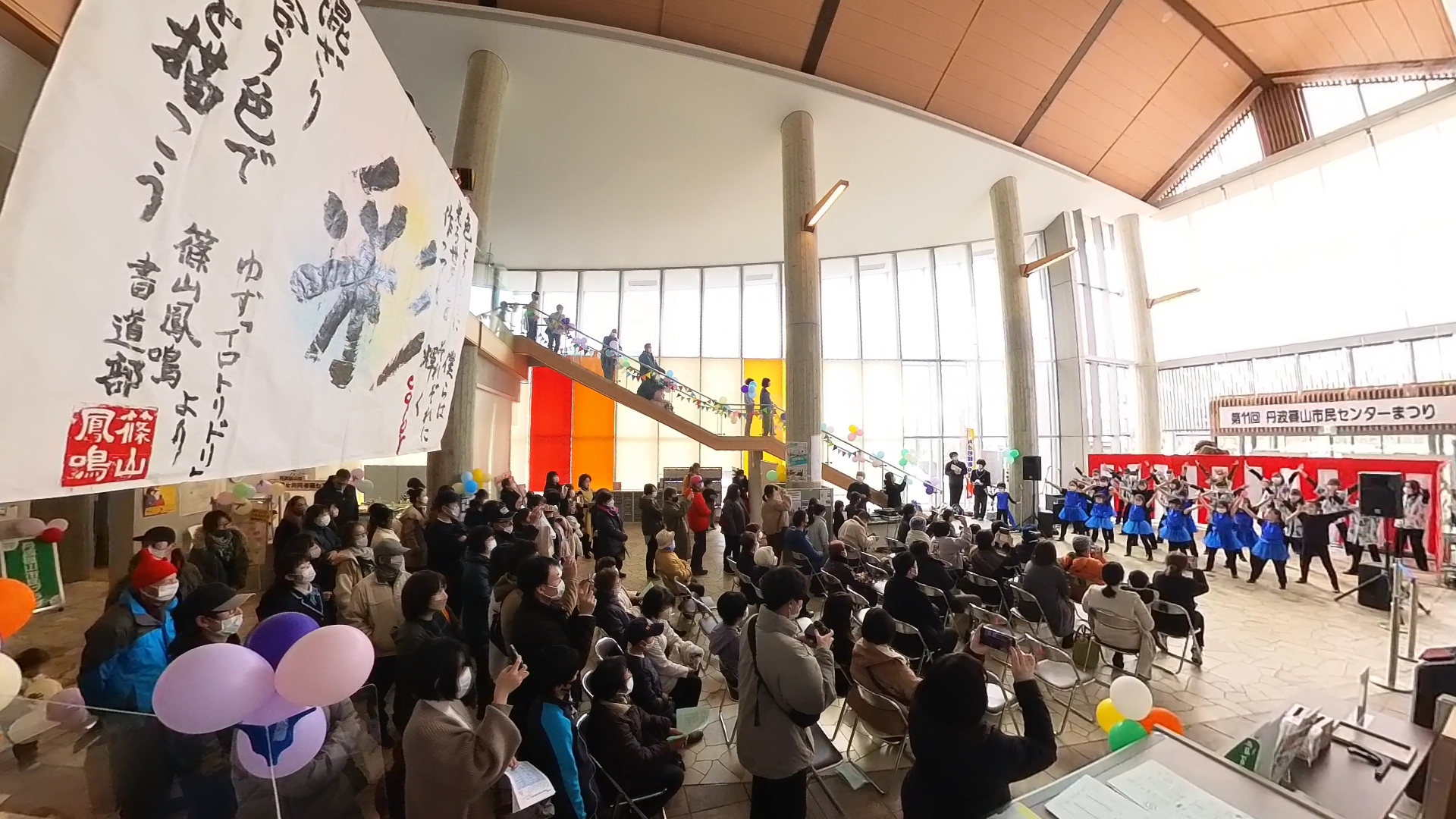 イベントのステージでおそろいの衣装を着たたちが踊っている