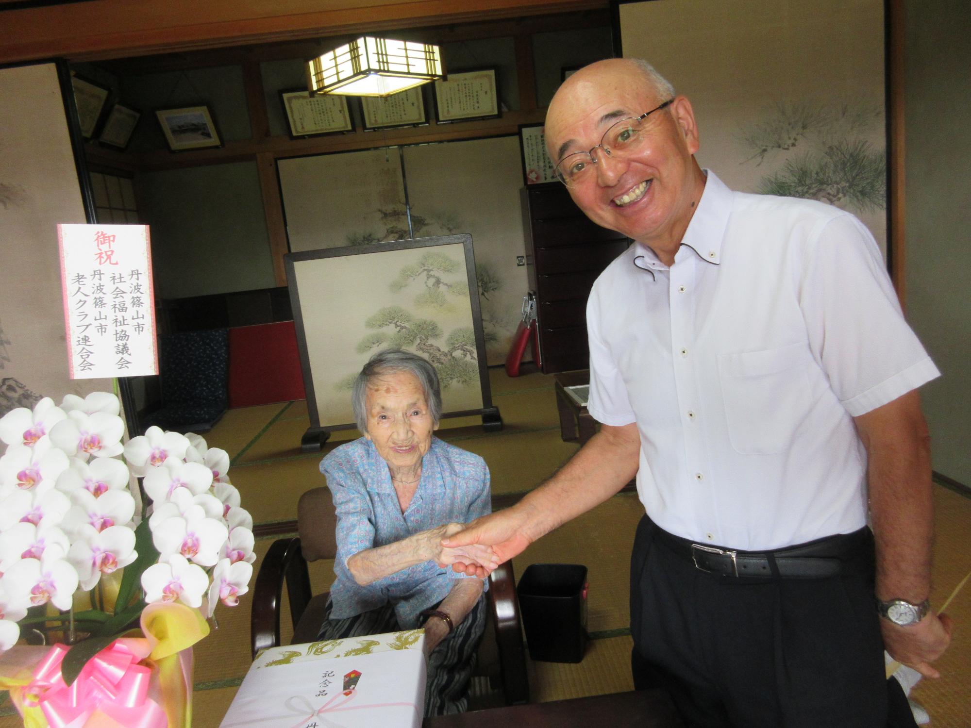 古屋しげこさんと握手をしている様子