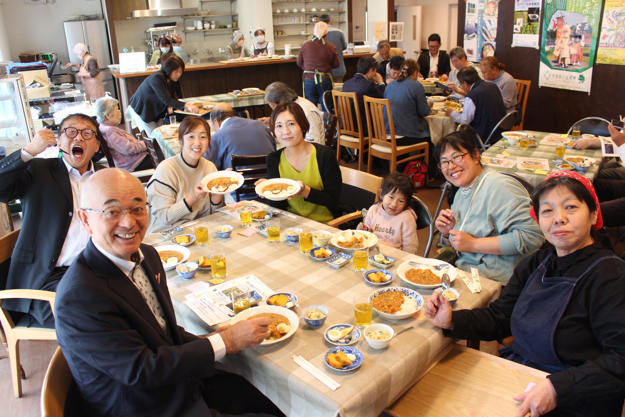 皆さんと一緒にカレーを食べている様子