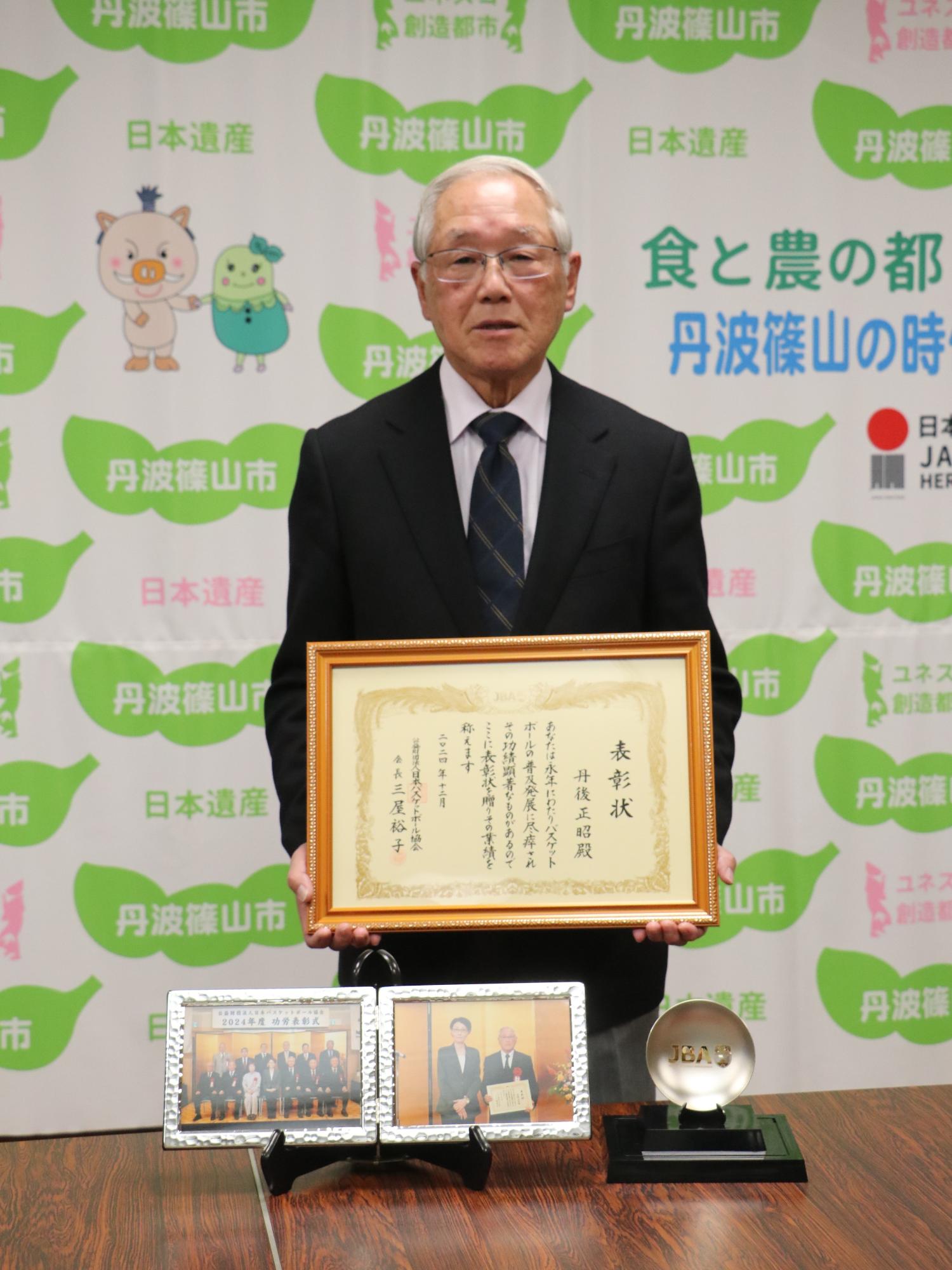 表彰状を持った丹後正昭さん