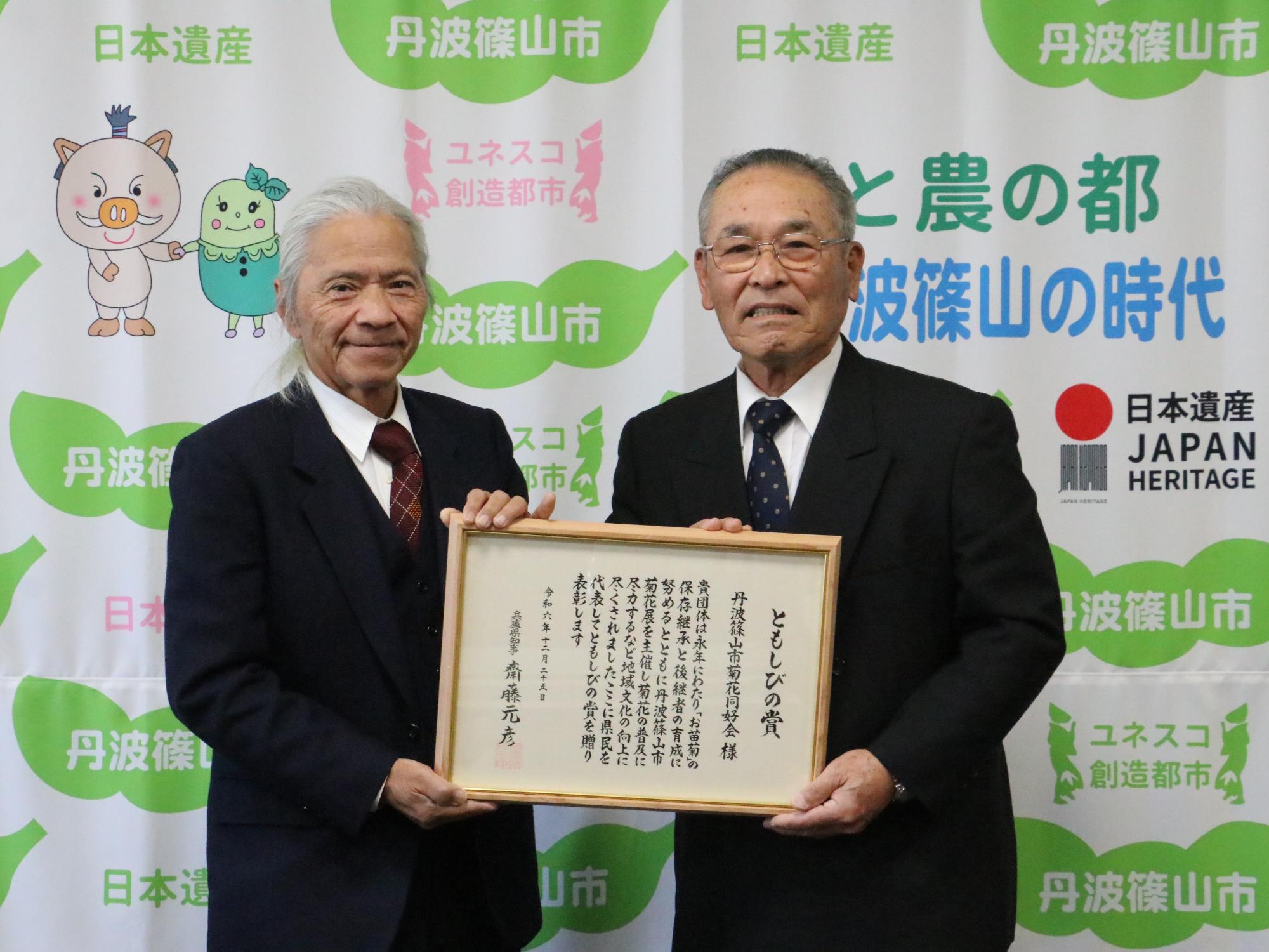 井田敏行さんと岸田士郎さん（表彰楯を持って撮影）