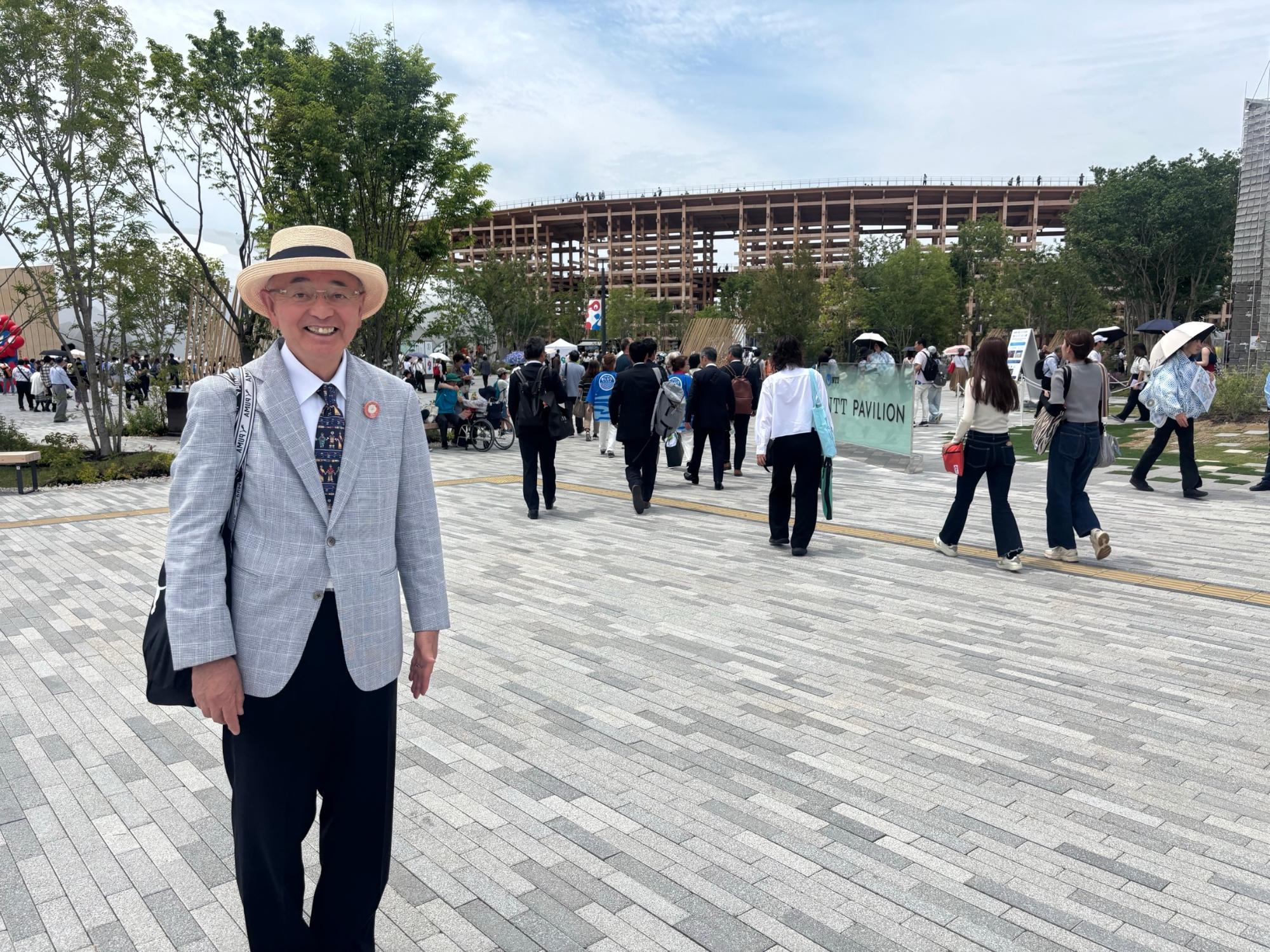 万博会場前をバックに酒井市長が写っている