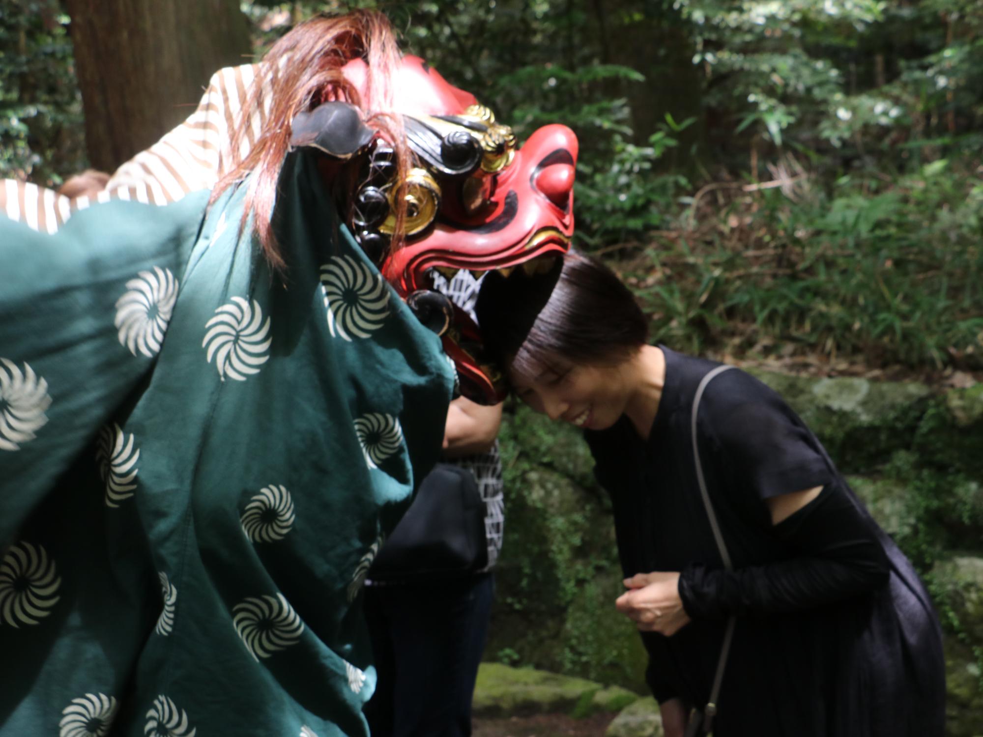 獅子舞にかんでもらう参加者