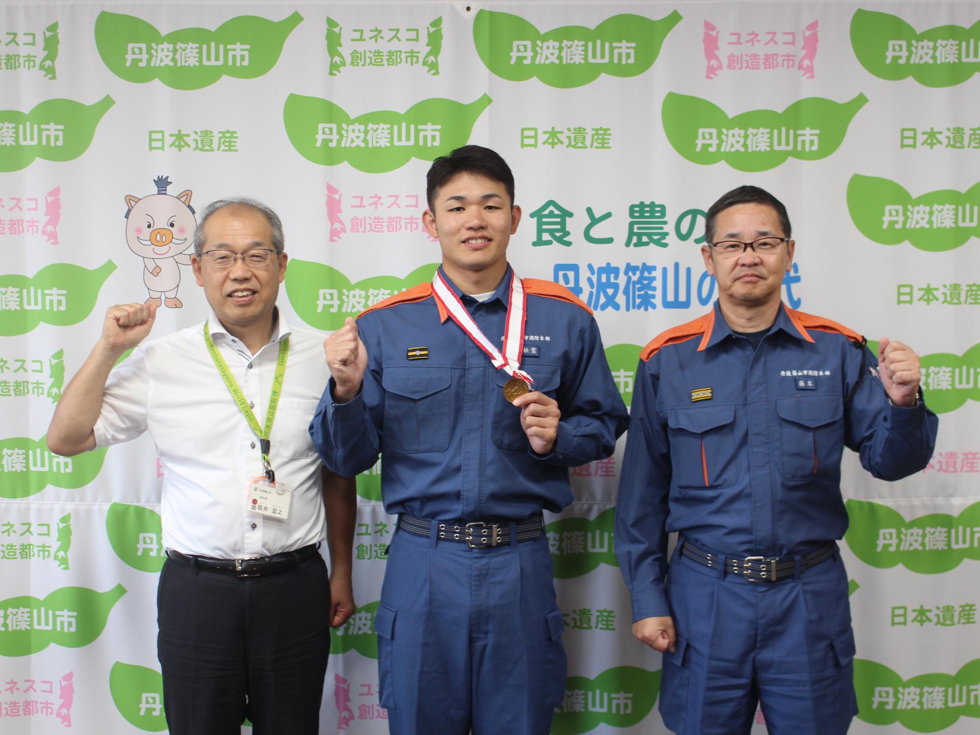 左から副市長、松葉さん、藤本消防長