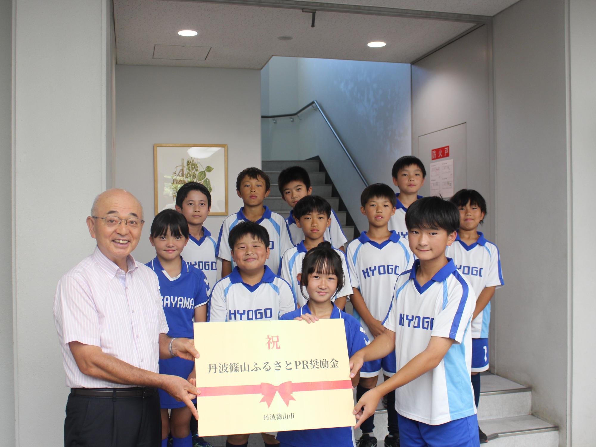 ホッケー小学生チームへふるさとPR奨励金贈呈の様子