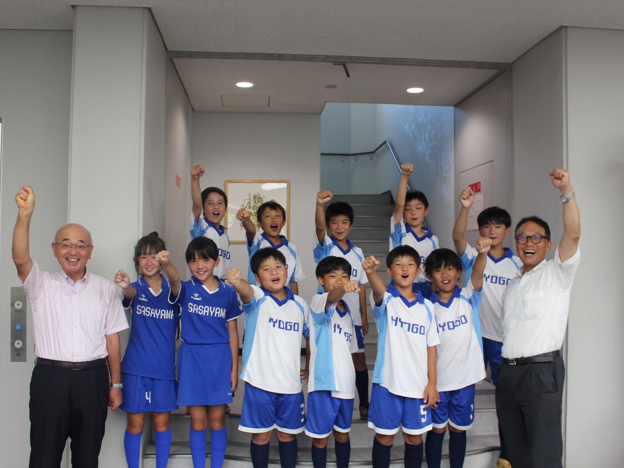 左から市長、ホッケー小学生チーム、教育長の集合写真