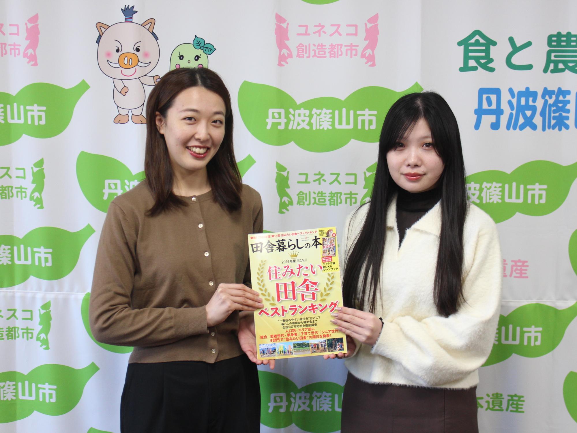 住みたい田舎ベストランキングの本を持つ市職員2人